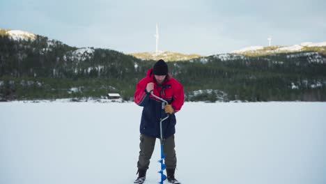 Man-Drill-A-Hole-With-Auger-In-A-Frozen-Lake-For-Ice-Fishing