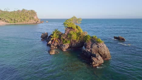 Luftaufnahme-Von-Felsen-Im-Karibischen-Meer-Mit-Wachsender-Palme-Bei-Goldenem-Sonnenuntergang---Punta-Balandra,-Samana
