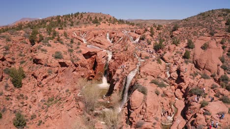 Aerial-view-of-several-waterfalls-forming-over-the-red-sandstone-cliffs-at-Gunlock-Reservoir-State-Park,-Utah