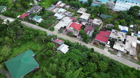 Aerial-panoramic-view-of-quiet-southeast-asia-roadway-with-buildins-nestled-in-trees