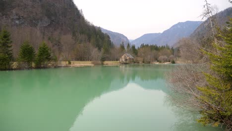 Static-shot-of-a-small-house-on-the-shore-of-a-private-tropical-lake-in-Slovenia