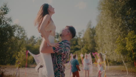 Young-man-lifting-girlfriend-while-dancing-bachata-at-beach