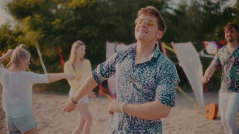 Young-carefree-man-wearing-sunglasses-grooving-against-friends