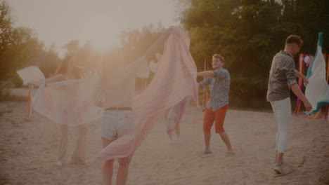 Young-men-and-women-swaying-sarongs-at-beach