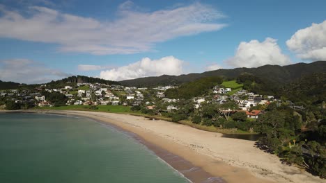 Sandy-beach-with-no-people,-popular-holiday-house-location-for-relaxation-in-Langs-Beach,-New-Zealand---aerial