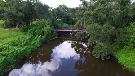 Drone-approaching-a-bridge-in-the-Wisner-Tract-Park-in-New-Orleans,-Louisiana