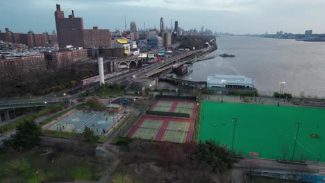 Urban-sports-courts-and-rec-facilities-in-NYC,-aerial-with-downtown-Manhattan