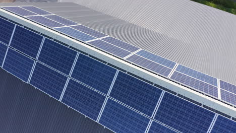 Downward-drone-view-of-solar-panels-mounted-on-either-side-near-roof-ridge