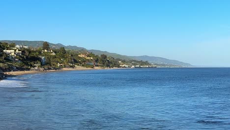 wide-establishing-shot-of-Malibu-beach-coastline-and-mountain-range-on-a-sunny-day-in-California