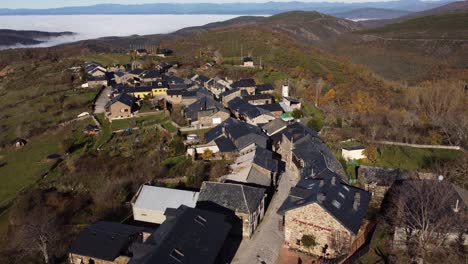 Aerial-view-of-a-charming-mountain-village-emerging-from-clouds