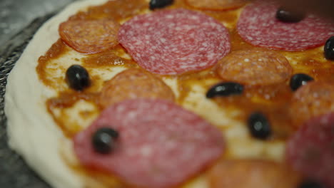 Making-italian-pizza-with-olives-and-salami