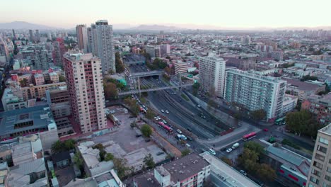 Drone-flyover-Residential-area-of-Santiago-downtown-towards-to-Santa-Ana-Metro-Station,-traffic-on-Central-highway
