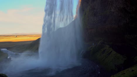 Fast-flowing-water-from-Seljalandsfoss-waterfall-in-Iceland,-panning-shot