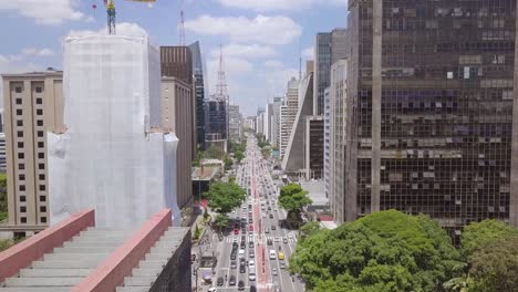Sao-Paulo's-busy-business-city-center-with-tourist-landmarks-and-buildings-in-Avenida-Paulista-street--aerial-footage-of-traffic-in-Brazil