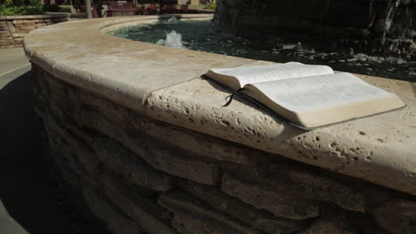 Heiliges-Buch-Vor-Einem-Friedlichen-Wasserbrunnen-Hintergrund