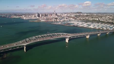 Aerial-reveal-of-Harbour-Bridge,-yacht-club,-harbour-and-city-centre