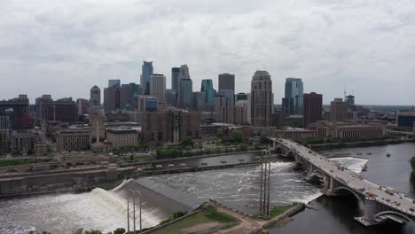 Wide-aerial-panning-shot-of-downtown-Minneapolis,-Minnesota-along-the-Mississippi-River