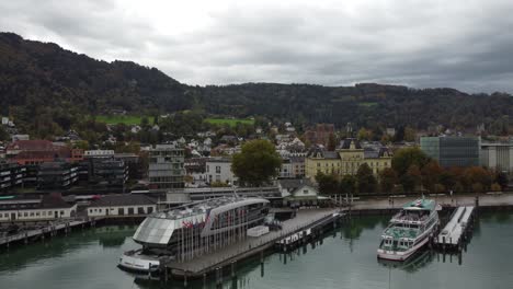 Aerial-view-of-historic-Bregenz,-you-can-see-the-ferry-in-the-port-on-a-cloudy-happy-autumn-day,-in-the-background-the-hills-with-forests-full-of-tranquility,-Vorarlberg,-Austria,-Europe