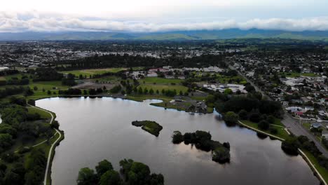 Birds-eye-view-of-Masterton-town,-landscape-over-Henley-Lake-Receation-Area,-Cloudy-day-in-New-Zealand
