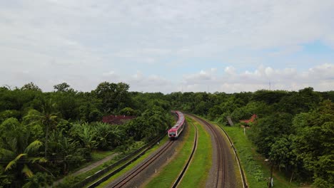 Drone-shot-of-a-train-running-on-rails-in-the-middle-of-countryside