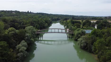 Disparo-Aéreo-De-Drones-Sobre-Un-Puente-Fluvial-En-Chalivert,-Francia