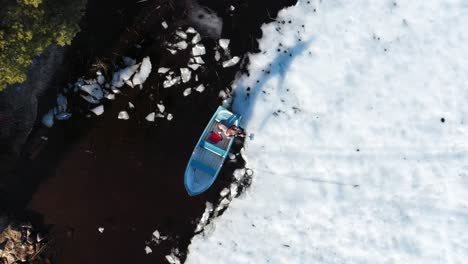 Mann-In-Einem-Boot,-Der-An-Einem-Wintertag-Mit-Einer-Schaufel-Eis-Bricht