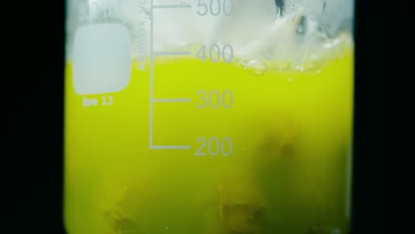 Behälter-Mit-Grüner-Flüssigkeit,-Die-In-Einem-Metallmesskolben-Sprudelt
