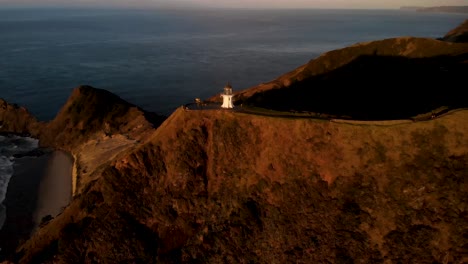 Aerial-View-Of-Cape-Reinga-Lighthouse-Near-Pointe-Panagiota-At-Sunset-In-Northland,-North-Island-Of-New-Zealand