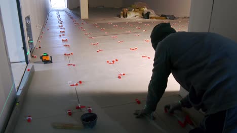 A-man-is-laying-ceramic-tiles-in-the-hallway