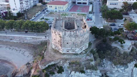 Medieval-tower-at-the-edge-of-the-sea-protecting-a-small-town-|-Aerial-shot-of-a-small-medieval-fortress-|-4K