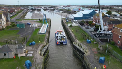 Boot-Durchquert-Schmale-Einfahrt-Zum-Yachthafen-In-Der-Abenddämmerung-An-Der-Mündung-Des-Flusses-Wyre-Fleetwood-Lancashire-Großbritannien