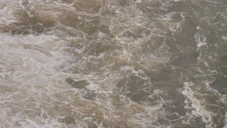 Handheld-shot-of-Hinze-Dam-water-flows-under-heavy-rain-during-La-Niña,-Gold-Coast-Hinterland,-Queensland,-Australia