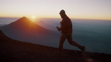 Hiker-Running-On-Ridges-Of-Acatenango-Volcano-With-Agua-Volcano-In-The-Background-During-Sunrise