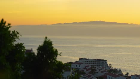 Seeing-la-Gomera-island-covered-in-fog,-from-Tenerife-during-sunset