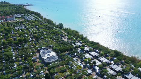 Panoramic-aerial-of-sunlight-glistening-on-beautiful-lake-garda-italy-homes