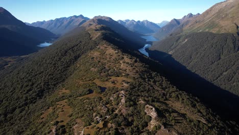 Aerial-scenic-view-of-Fiordland-National-Park-in-the-morning,-high-mountain-peaks-and-lakes-in-valley