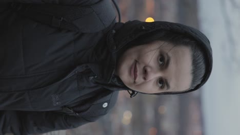 Vertical---European-Woman-In-Hooded-Winter-Jacket-Admiring-Cityscape-Of-Jonkoping-In-Sweden
