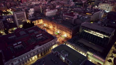 Aerial-view-approaching-Palace-of-the-Courts-of-Justice-of-Santiago-illuminated-historical-building-exterior-at-night