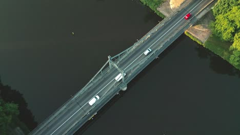 Top-down-shot-of-cars-driving-on-the-steel-bridge-over-the-river