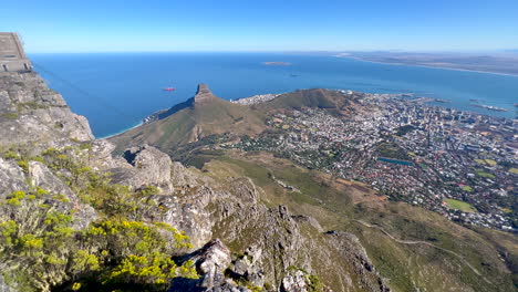 Top-of-the-world-Table-Mountain-Cape-Town-South-Africa-gondola-stunning-epic-morning-view-downtown-city-Lions-Head-hike-fitness-exercise-lush-spring-summer-grass-flowers-green-deep-blue-sea-pan-right