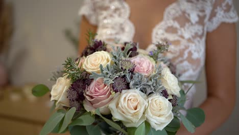 Beautiful-bride-in-wedding-dress-holding-rose-flowers-bouquet,-Orbiting-shot