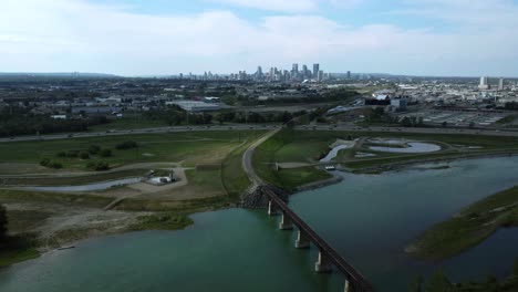 Drone-footage-revealing-downtown-cityscape,-industrial-area,-and-highway,-Calgary,-Alberta,-Canada