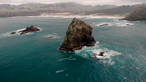 Spectacular-nature-aerial-around-rock-formation-reveal-Sandfly-Bay,-Otago-Peninsula