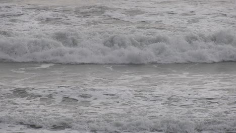 waves-crash-against-beach-on-stormy-day