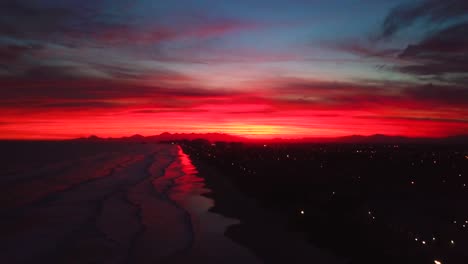 Aufnahme-Einer-Langsamen-Luftaufnahme-Des-Späten-Abendsonnenuntergangs-Am-Meeresstrand-Von-Itanhaem,-Verrückter-Farbhimmel-In-Brasilien