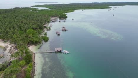 Drohne-Steigt-über-Die-Insel-Balabac-Mit-Palmen,-Banca-Kanu-Und-Haus-Auf-Dem-Wasser