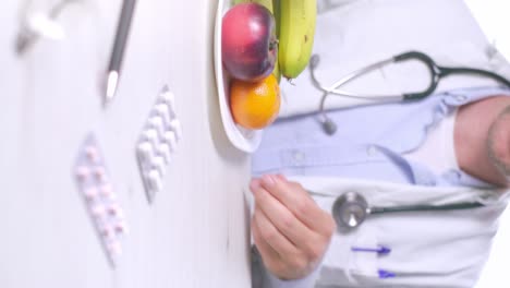 Vertical-video,-doctor-puts-aside-cakes-plate-and-showing-Fruit-plate,-Diet-concept