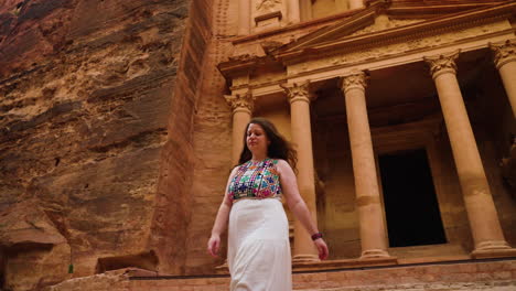 Female-Traveler-Walking-Down-The-Stairs-Outside-The-Treasury-In-Archaeological-City-Of-Petra-In-Jordan