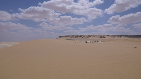 Camp-in-the-desert-under-a-cloudy-sky---wide-shoot---pan-right