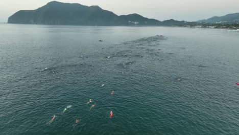 Swimmers-Racing-In-The-Ocean-During-Triathlon-Contest-In-The-Early-Morning